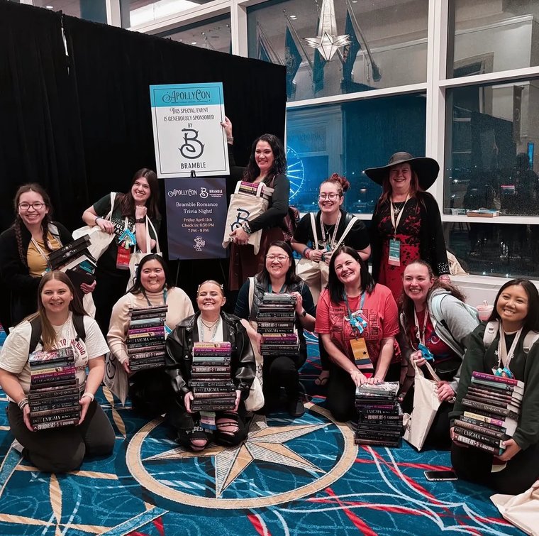 Readers with stacks of books at a book convention