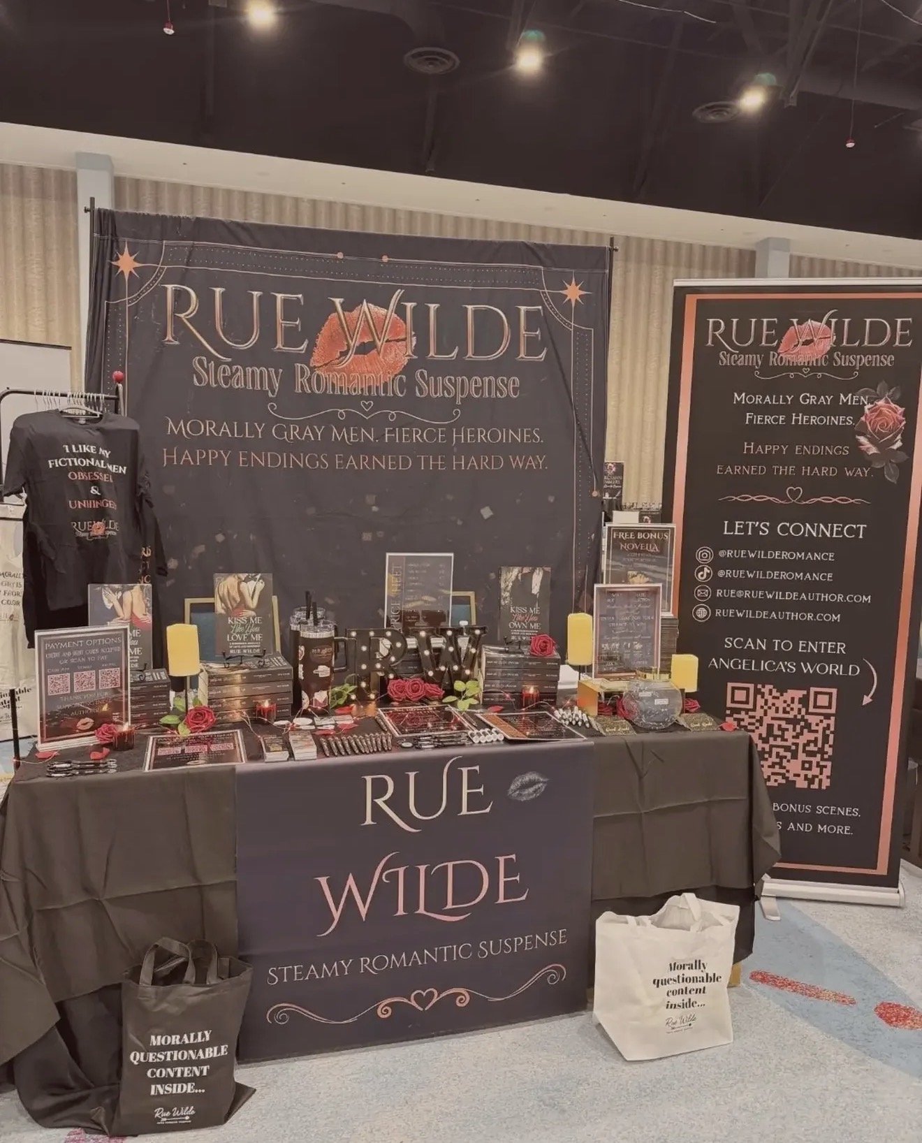 Rue Wilde author event table setup with banners, merch and signage
